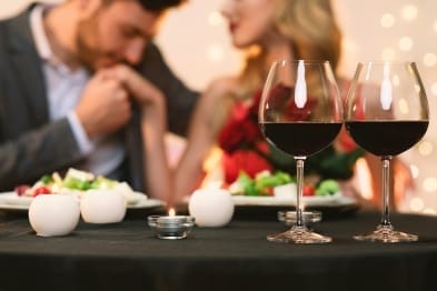 Packages & Specials 3 A group of people sitting at a long table with wine glasses, enjoying a social gathering.
