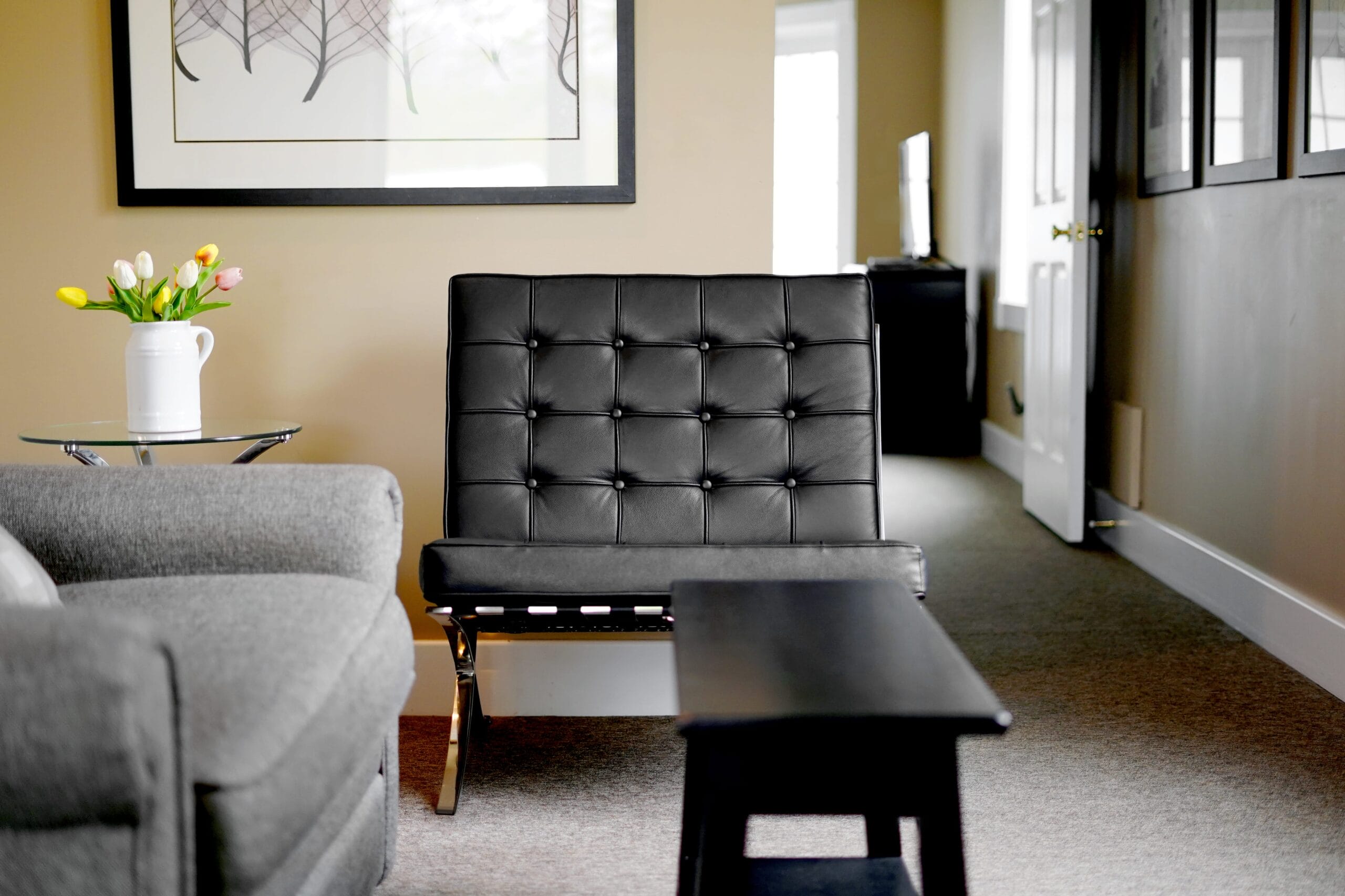 Interior with a gray chair and a black table.
