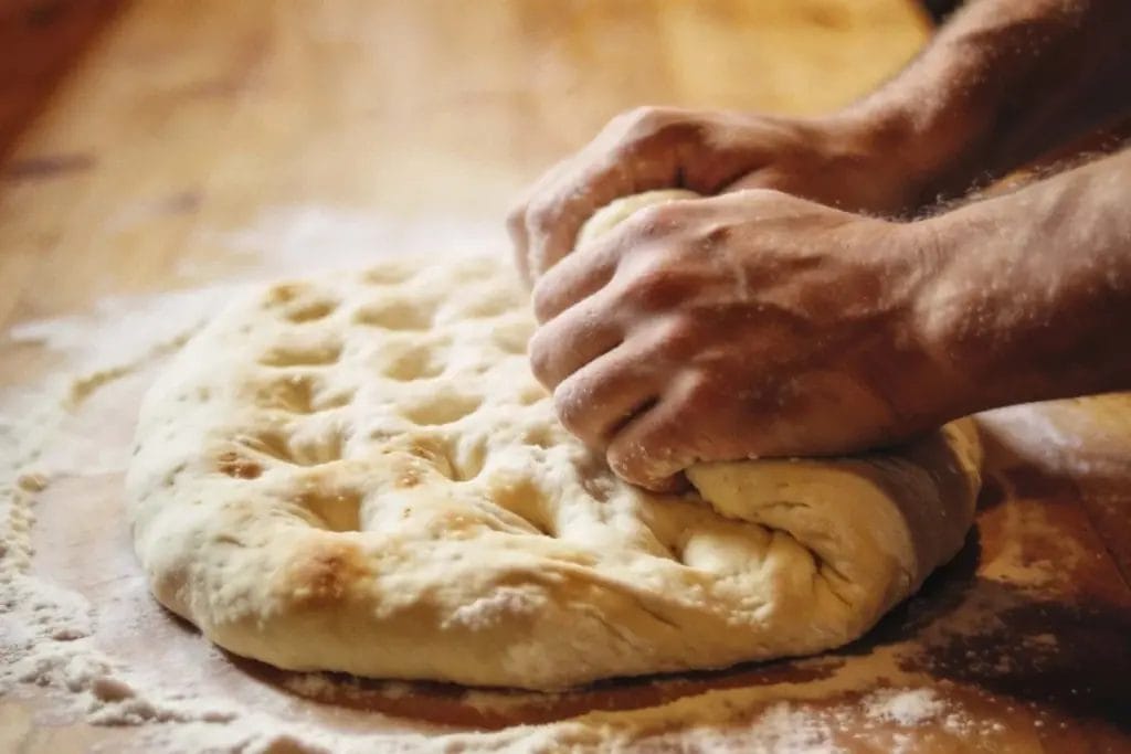 Person kneading dough for focaccia