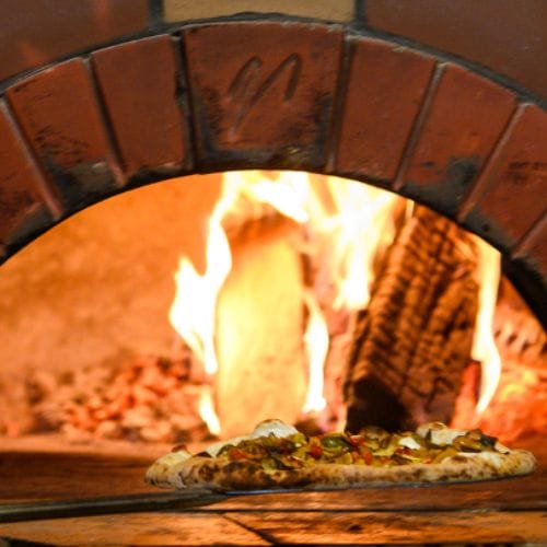 Cooking Classes 1 Pulling a pizza from a wood-fired oven.