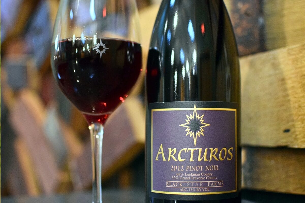 Bottle of an older vintage of Pinot Noir with a glass of red wine.